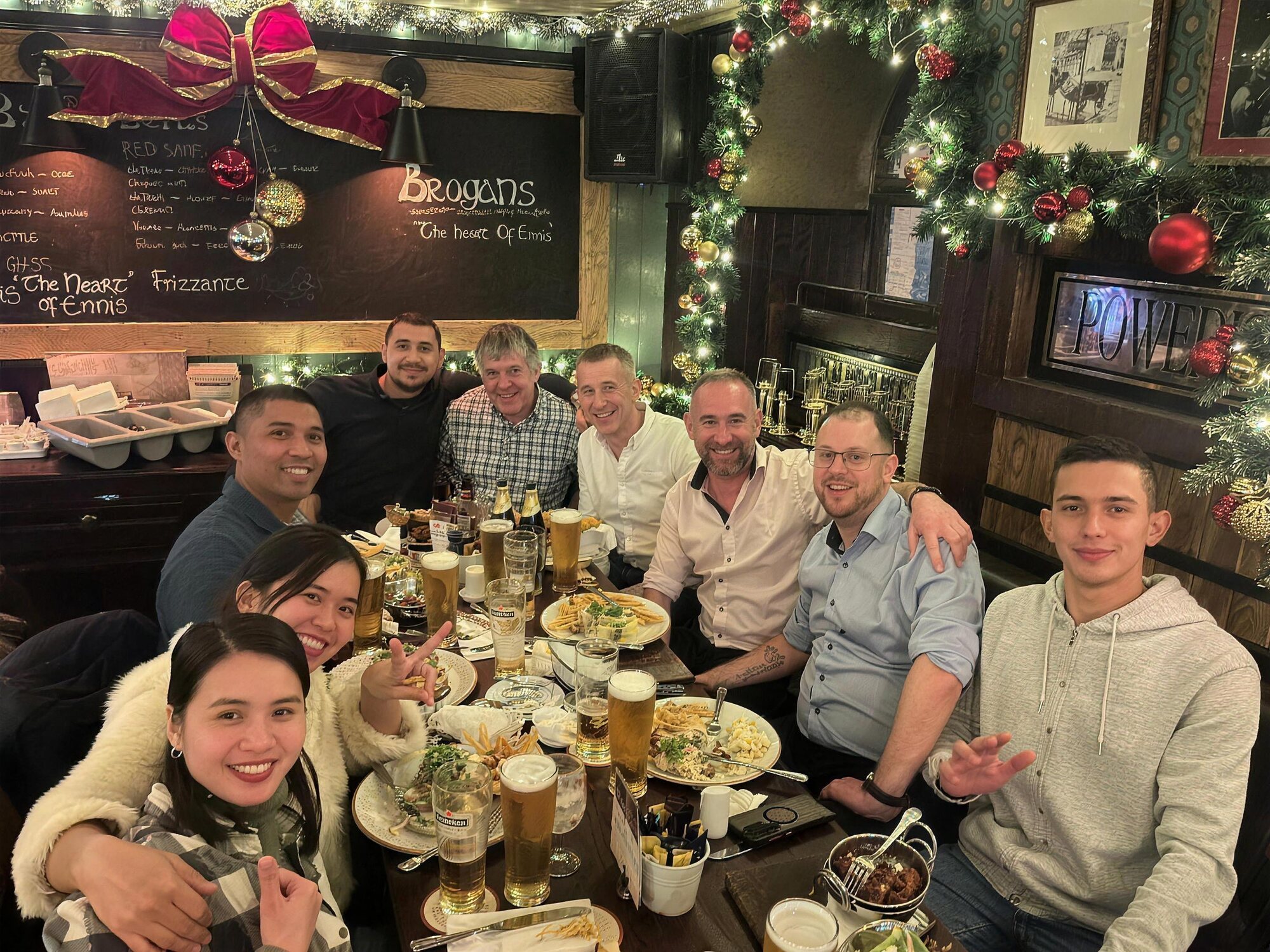 The Kilfilum crew gathered around a long table after work, smiling at the camera.